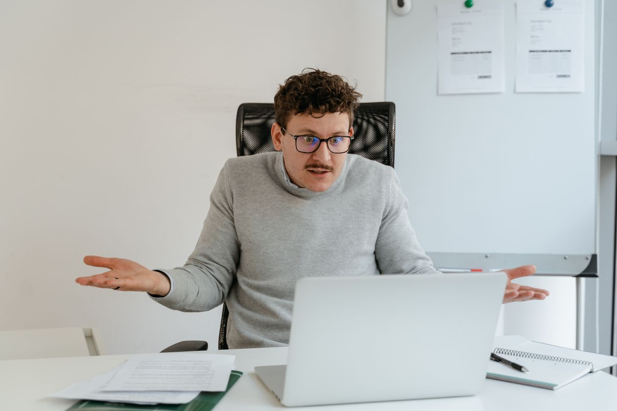 Confused business owner shrugging at his desk, unsure where his numbers stand